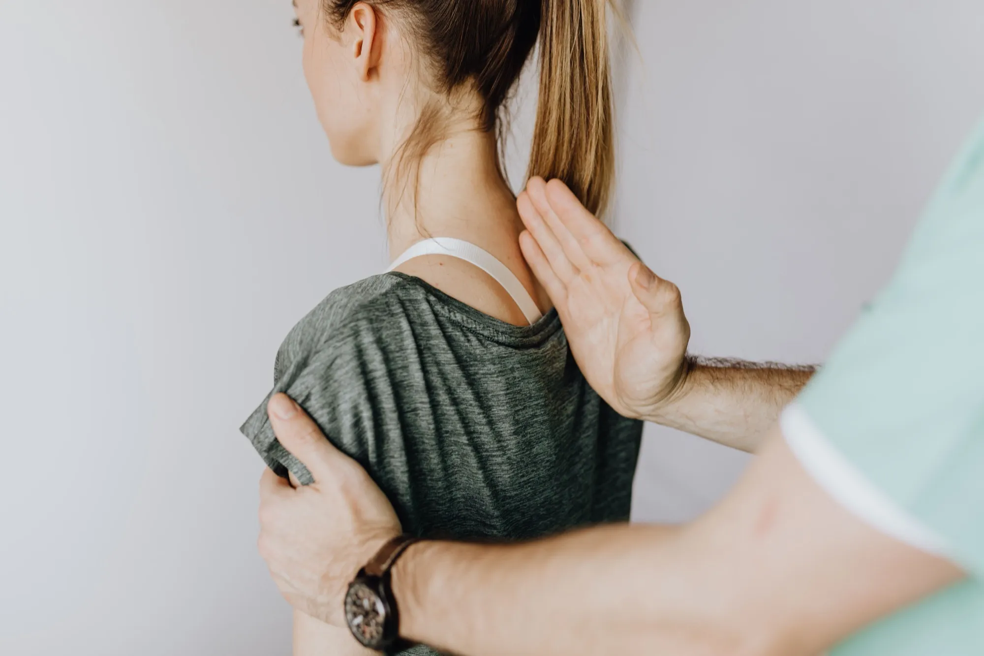 A clinician assessing a patient's shoulder and scapular movement